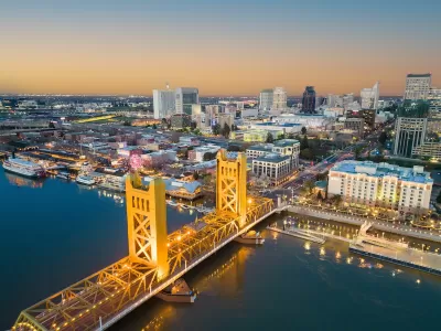View of Tower Bridge over Sacramento River and downtown Sacramento, California at dusk.
