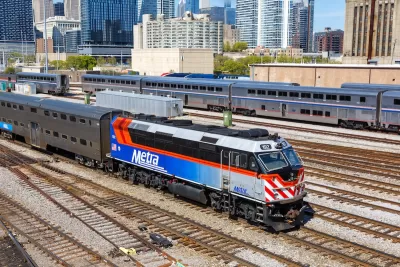 Blue, white, and red Metra commuter train with Chicago buildigns in background.