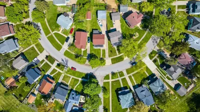 Bird's eye view of half-circle suburban street with large homes.