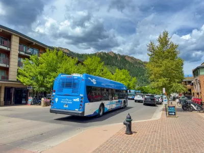 Blue public transit bus on street with mountains in background in Aspen, Colorado.