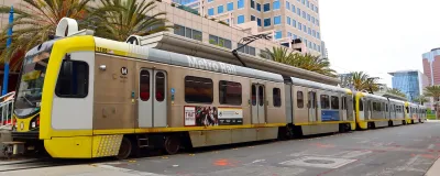 Yellow and silver light rain train in downtown Long Beach, California.