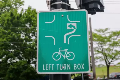 Close-up of green sign for bike box for turning in intersection.