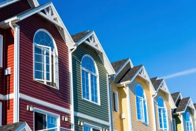 Close-up of row of colorful townhouses with triangular roofs
