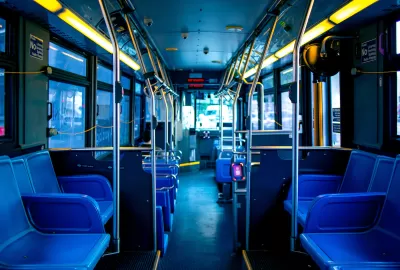 Empty interior of New York City bus with blue seating.
