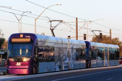 Purple Phoenix light rail train on rail at golden hour.