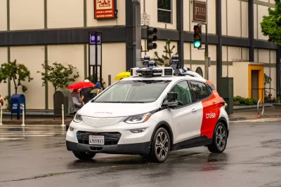 White and red Cruise autonomous car on San Francisco street.