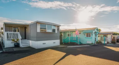 Row of colorful mobile homes on an asphalt street.