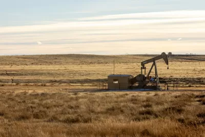 Oil well in prairie landscape.