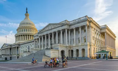 Wide shot of group of people with bikes standing in plaza near U.S. Capitol in Washington, D.C.