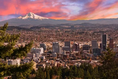 Sweeping view of Portland, Oregon with Mt. Hood in background against sunset sky.