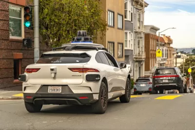 White Waymo self-driving car on street in San Francisco, California.