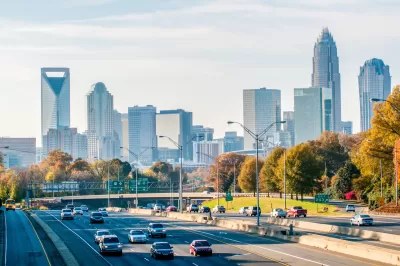 View of cars on freeway with Charlotte, North Carolina skyline in background.