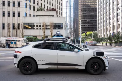 White Waymo autonomous SUV taxi on San Francisco street.