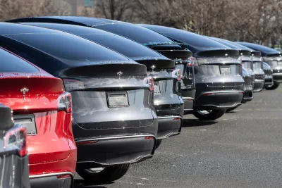 Low view of row of red, grey, and black Tesla electric cars.