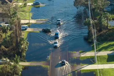 Aerial view of cars evacuating flooded residential neighborhood in Florida.