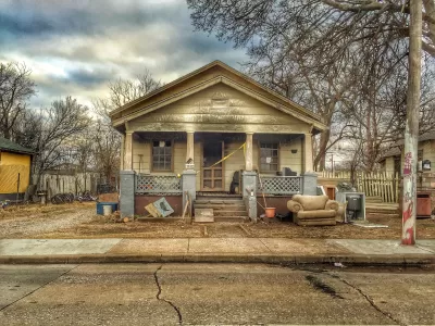 Old single-story home with porch in run-down condition