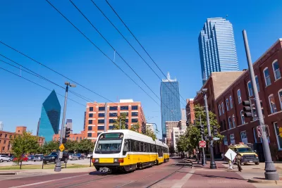 White Dallas light rail car with Dallas skyline in background