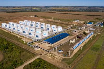 Aerial view of hydrogen storage hub in green field.