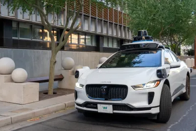 White self-driving Waymo vehicle on street in Phoenix, Arizona.