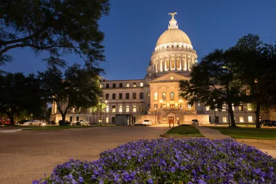 Mississippi state capitol dome at night with purple flowers in foreground in Jackson, Mississippi.