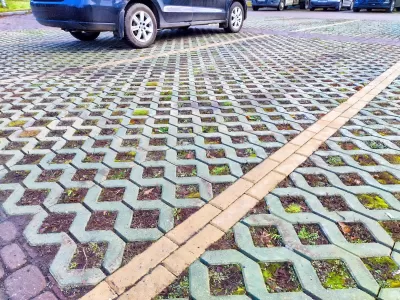 Close-up of green permeable street with concrete lattice over soil and grass.