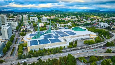 Downtown Portland, Oregon with convention center in foreground with green glass spires and rooftop solar panels visible.