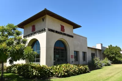 Corner view of Spanish revival-style building with arched windows, red tile roof, and Long Beach City College title and logo on two sides.