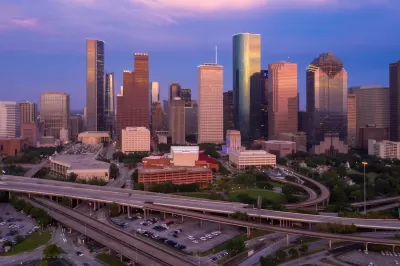View of downtown Houston with elevated freeways in foreground at dusk.