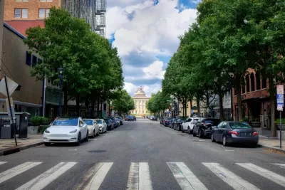 Crosswalk on street in Raleigh, North Carolina with parking on both sides and capitol building visible in background.