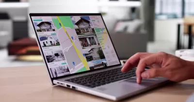 Close-up of laptop with real estate listings shown on map.