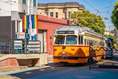 Orange and white vintage-look streetcar on Market Street in San Francisco, CA.