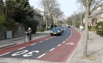 Advisory bike lane in The Netherlands with bike rider and cars in center lane
