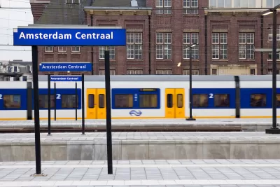 A local train is in motion on one of the platforms at the Amsterdaam Centraal train station.