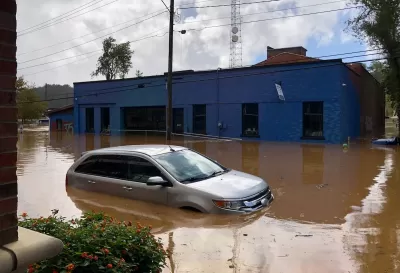 Car half submerged in brown flood water in Asheville, North Carolina after Hurricane Helene.