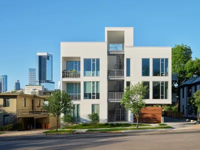 Rendering of white three-story single-stair building in Austin, Texas with staircase in the middle.