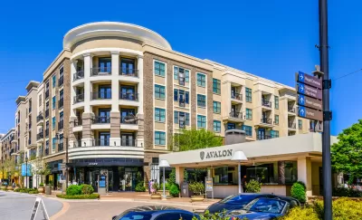 A mid-rise building with retail and apartments. A car port announces the name of the development: Avalon.