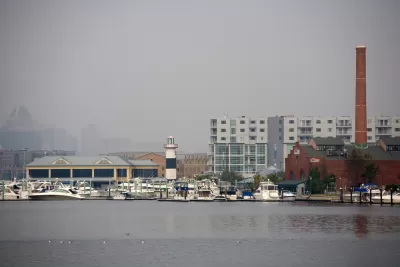 The city of Baltimore's Inner Harbor blanketed in fog, as seen from the water.