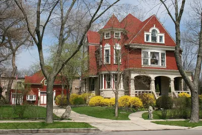 Red brick mansion with white trim in Chicago with small red brick coach house next to it.