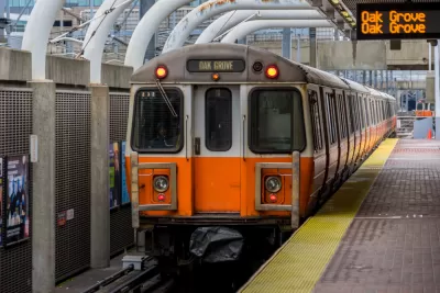 An MBTA Orange Line train bound for Oak Grove waits at a station.