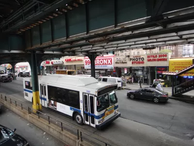 A New York MTA drives down the straight under elevated train tracks in the Bronx in New York City
