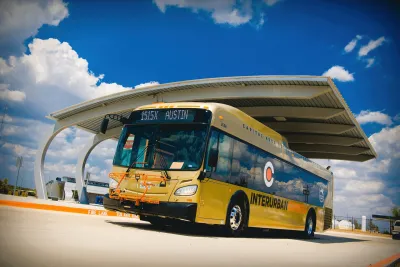 Yellow CARTS bus pulling out of covered parking bay.
