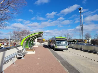 Green and silver CTfastrak bus at a station in Elmwood, Connecticut.