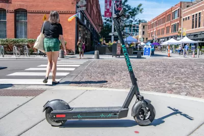 An electric scooter blocks the sidewalk near a street festival in Chicago's West Loop.