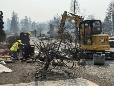 City workers in yellow vests and hard hats working to shut off water infrastructure after wildfire in destroyed neighborhood in Spokane, Washington.