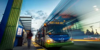 Low view looking up at bus rapid transit bus at station in Snohomish County, Washington with blur to indicate motion.