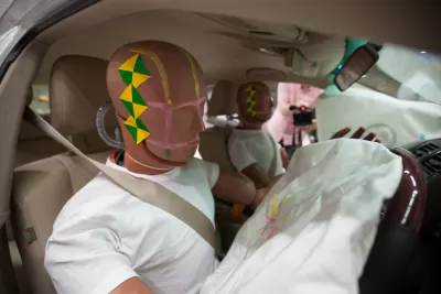 A pair of crash test dummies in a car after a crash with air bags deployed.