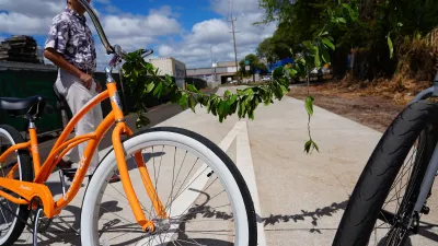 Close-up on orange cruiser bike decorated with garland of leaves on Pearl Harbor Bike Path.