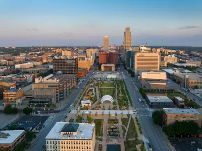 An aerial view of a park and the streets and high-rises of Downtown Omaha.