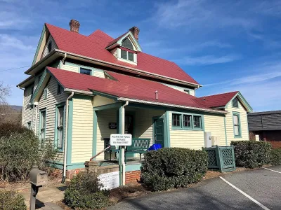 Pale yellow Sears kit house with red tile roof in Sylva, North Carolina.