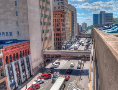 A busy street in Duluth, full of cars and buses.